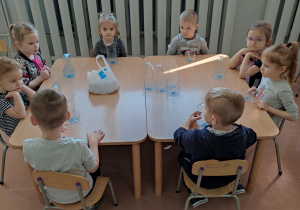Grupa dzieci przy stoliku.