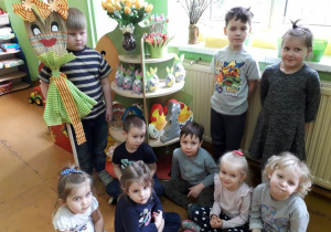 Dzieci zebrane wokół marzanny w kąciku przyrodniczym.