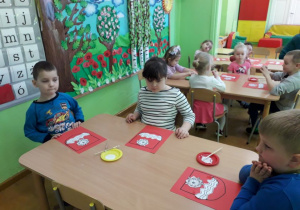 Dzieci przy stolikach wykonują herb Gminy Wartkowice.