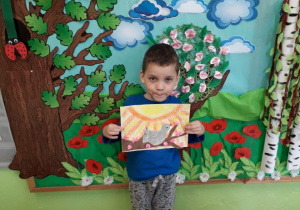 Chłopiec prezentuje ilustrację do baśni "Słowik".