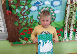 Chłopiec prezentuje ilustrację do baśni "Brzydkie kaczątko".