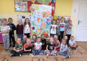 Przedszkolaki prezentujące wykonany jesienny plakat