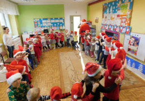 Dzieci ustawione w pociąg za Mikołajem i tańczące przy rytmach piosenki "Maszynista zuch"