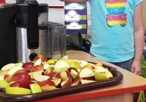 Dziecko robi sok jabłkowy.