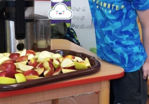 Dziecko robi sok jabłkowy.