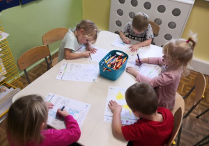 Dzieci siedzące przy stoliku i kolorujące obrazek w ramach akcji "Dzieci uczą rodziców"