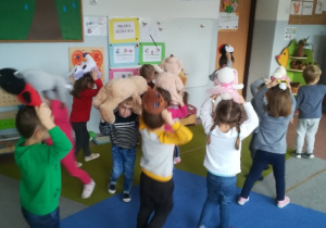 Młodsza grupa dzieci tańczy z maskotkami.
