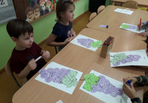 Dzieci z fioletowych kółek wykonują winogron.