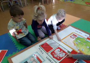 Dzieci tworzą tablicę tematyczną "Polska moja ojczyzna".