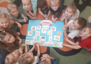 Dzieci leżące dookoła wykonanego plakatu o prawach dziecka