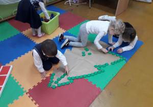 Dzieci układają z klocków konstrukcyjnych drzewko choinkowe.