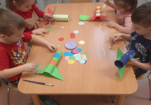 Dzieci wykonują prace plastyczną "rakiety".
