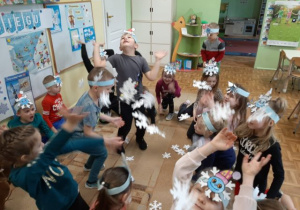 Przedszkolaki podczas zabaw ruchowych z wykorzystaniem papierowych śnieżynek