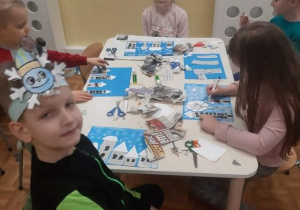 Grupa 5,6-latków wykonująca prace plastyczne z okazji Dnia Śniegu