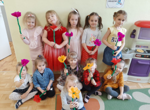 Dziewczynki pozujące z kolorowymi kwiatkami wykonanymi z bibuły