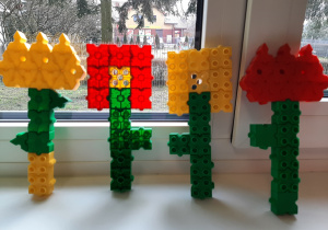 Wystawa kwiatków z plastykowych klocków skonstruowanych przez chłopców dla dziewczynek z okazji dnia kobiet