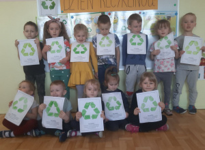 Dzieci prezentujące pokolorowany rysunek ze znakiem recyklingu
