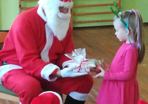 Dziewczynka dostaje prezent od Mikołaja.