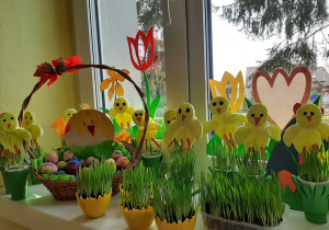 Wiosenno - wielkanocny kącik grupy 5,6 latków z wielkanocnymi jajkami i ozdobami wśród wschodzącego, zielonego owsa
