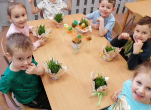 Dzieci z grupy 3 - 4 latków w czasie dekorowania jajkami doniczek z owsem