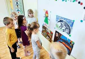 Kilkoro dzieci z grupy 3,4,5 latków oglądająca obrazki przedstawiające krasnala Hałabałę i borsuka, kolejne ujęcie.