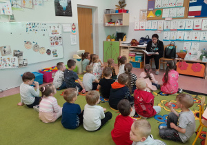Dzieci słuchają bajek Marii Konopnickiej czytanych przez bibliotekarkę