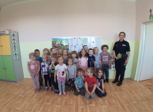 Dzieci z młodszej grupy podczas wspólnego zdjęcia z policjantką z Poddębic
