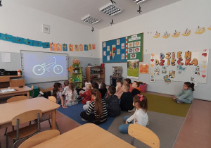 Dzieci oglądają na tablicy interaktywnej budowę roweru