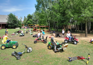 Przedszkolaki bawią się na placu zabaw pojazdami