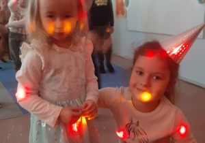 Dziewczynki podczas zabawy w blasku kolorowych światełek