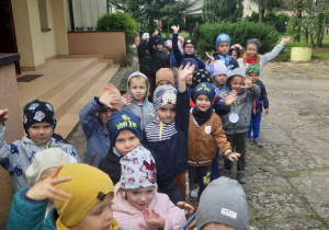 Grupa dzieci podczas wyjścia z budynku przedszkola na spacer