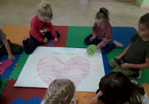 Dzieci wspólnie wykonują plakat "Emocje w moim sercu".