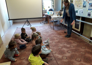 Dzieci słuchają opowiadania pani bibliotekarki o polskich wynalazcach.