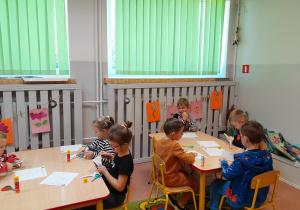 Dzieci wykonują kartę pracy przy stolikach