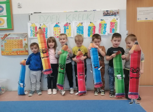 Dzieci trzymają kolorowe kredki z papieru
