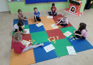 Dzieci na dywanie podczas zabawy z kluczmi.