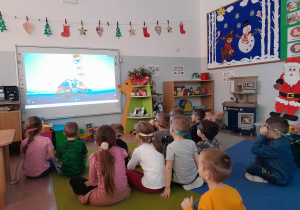 Przedszkolaki siedzą oglądają film na temat pierwszego objawu udaru