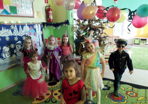 Dzieci prezentują swoje kostiumy na balu karnawałowym.