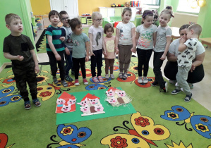 Przedszkolaki prezentują wykonane w grupach domki z baśni "Trzy świnki".
