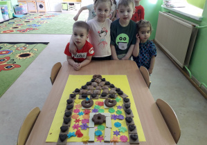 Dzieci prezentują wykonaną chatkę z piernika.