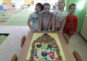 Dzieci prezentują wykonaną chatkę z piernika.
