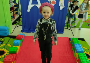 Pokaz mody francuskiej- dziewczynka w stroju małej Francuzki.