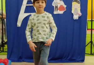 Pokaz mody francuskiej- chłopiec prezentuje styl sportowy.