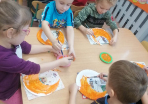 Dzieci malują szablony kotów przy stolikach