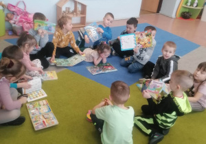 Dzieci z wypożyczonymi książkami w sali przedszkolnej
