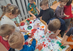 Dzieci z grupy 3-4 latków malują wspólny obraz