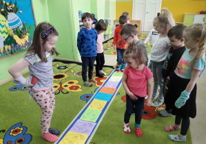 Dzieci uczestniczą w zabawie "Skarpetkowy tor przeszkód".