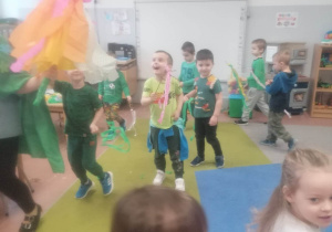 Dzieci tańczą w sali z gaikami i kukłą