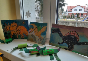 Wystawa prac plastycznych namalowanych przez dzieci oraz papierowych figurek dinozaurów.