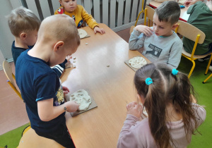 Dzieci podczas zabawy manualnej przy stolikach
